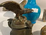 a statue of an eagle sitting on top of a blue vase