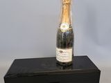 une bouteille de champagne posée sur une boîte noire