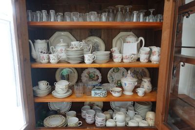 une armoire en bois remplie d'une multitude d'assiettes et de tasses
