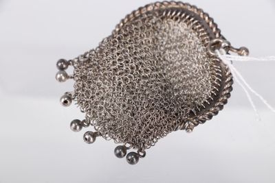 un gros plan d'un sac à main en treillis métallique entouré d'une chaîne