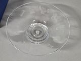 a clear glass bowl with a blue handle on a table