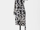 une robe noire et blanche posée sur un présentoir pour mannequin