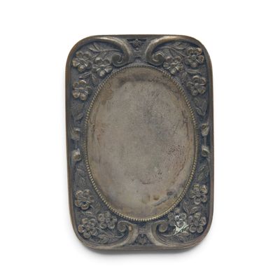 une assiette ancienne en argent, ornée d'un motif floral sur le bord