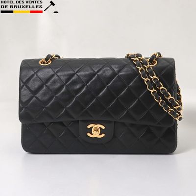 un sac à bandoulière Chanel en cuir matelassé noir, avec des finitions dorées