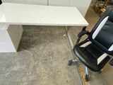 un bureau blanc avec une chaise noire à côté