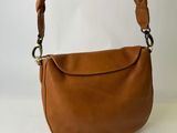un sac à main en cuir marron avec des anses tressées, sur fond blanc