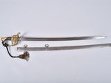 a close up of two swords on a white surface