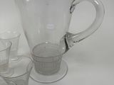 a lot of glasses and a pitcher sitting on a table