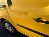 a yellow van parked in a parking lot next to a building