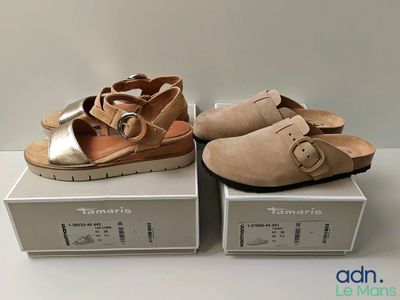 two pairs of women ' s sandals are sitting on top of boxes