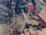 a tractor that is sitting in the dirt with a plow behind it