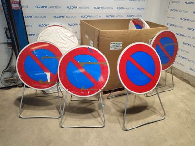 four red and blue no parking signs sitting in front of a cardboard box