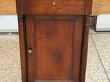 une petite armoire en bois montée sur roulettes, posée au sol