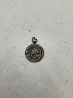 une vieille pièce de monnaie repose sur une surface blanche