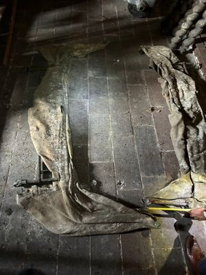 un homme qui est en train de découper un morceau de tissu par terre