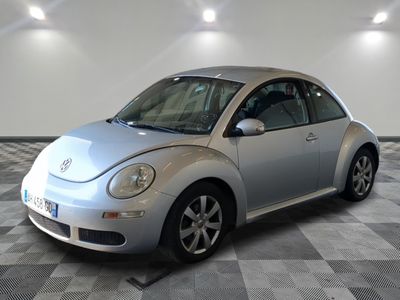 une photo d'une Coccinelle Volkswagen argentée garée dans un garage