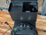 a black box with a green battery in it on a wooden table