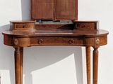 a small wooden table with a mirror on it