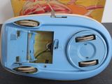 a blue and white alarm clock sitting on a table