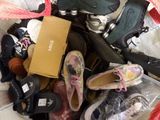 many pairs of shoes that are sitting on a bed