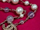 pearl and amethe necklace with a turtle charm on a pink background