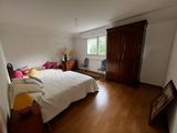 a bedroom with a bed, dresser, and a window
