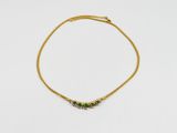 un bracelet en or orné d'émeraudes sur fond blanc