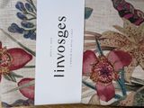 a white tag on a floral pillow that says invoges