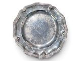 une plaque d'argent sur une surface blanche avec un fond blanc