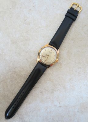 une image représentant une montre posée sur un bracelet noir