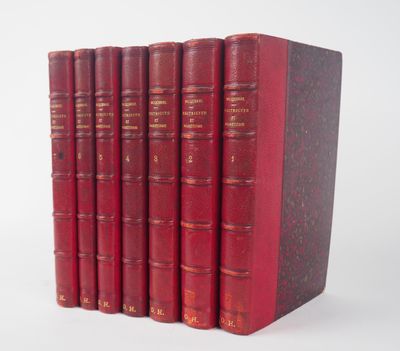 six livres rouges alignés sur une surface blanche