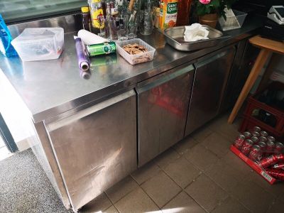 un plan de travail en inox sur lequel sont posées plusieurs bouteilles
