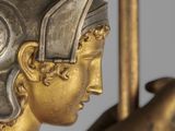 a gold statue of a woman holding a sword