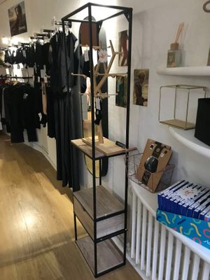 un portemanteau dans un magasin de vêtements, sur lequel sont suspendus des vêtements