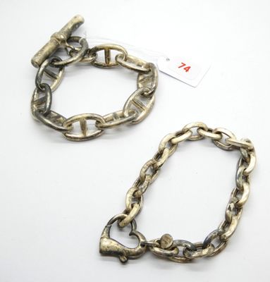 deux bracelets en argent posés sur une surface blanche