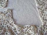 a piece of white lace on a table with a white cloth