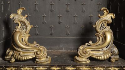 two gold colored sculptures on display in a room