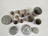 a lot of silver coins and silver cups on a white surface