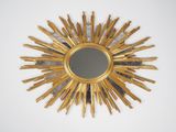 un miroir doré en forme d'étoile accroché au mur