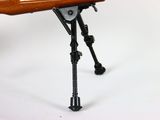 a toy gun on a tripod on a white surface