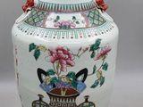 un grand vase orné de fleurs, posé sur un socle