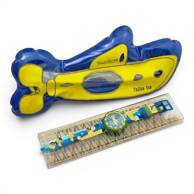 a yellow and blue toy boat and a ruler on a white background