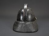 an old helmet is sitting on top of a gray surface