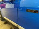 a close up of a blue car with a sticker on it