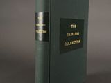 an old book with a black cover sitting on a table