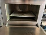 a metal oven that has some food inside of it