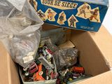 a cardboard box filled with assorted toys on a white surface