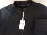a close up of a black jacket with a tag on it