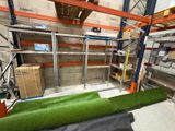 un tapis vert posé à même le sol dans un entrepôt