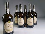 plusieurs bouteilles de vin sont alignées sur une surface blanche